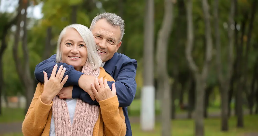 Dating Profil Tipps: lächelndes Paar über 50 umarmt sich im Park