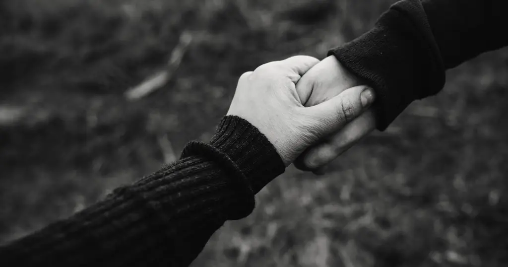 Erste Nachricht Online Dating: zwei Hände greifen ineinander, in Schwarz-Weiss