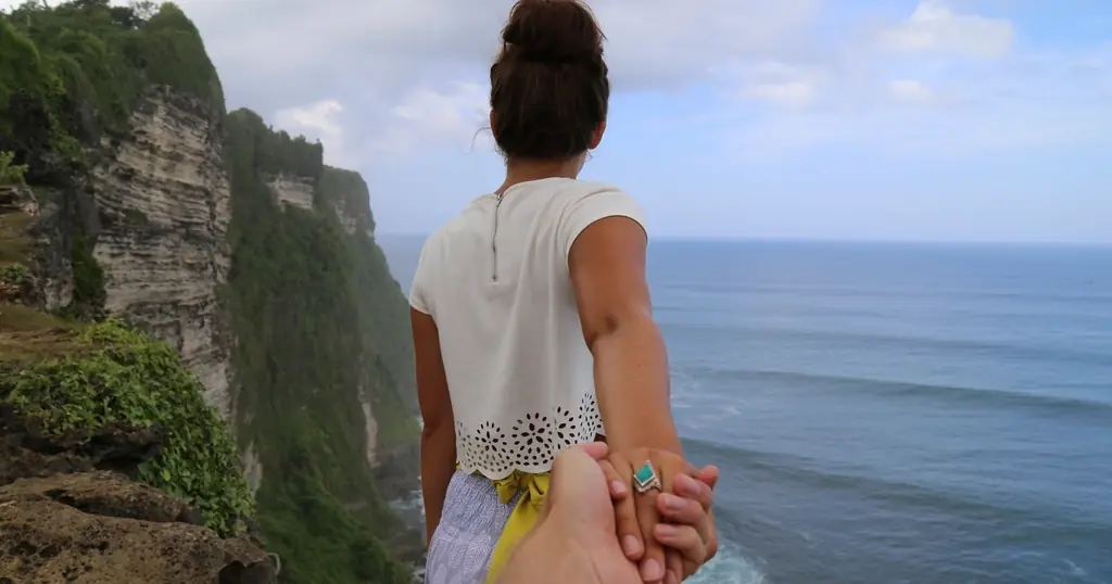 Nach Trennung wieder daten: Frau an einer Steilküste über dem Meer hält eine Hand hinter sich