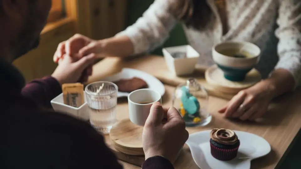 Partnersuche online: zwei Menschen beim ersten Treffen im Café